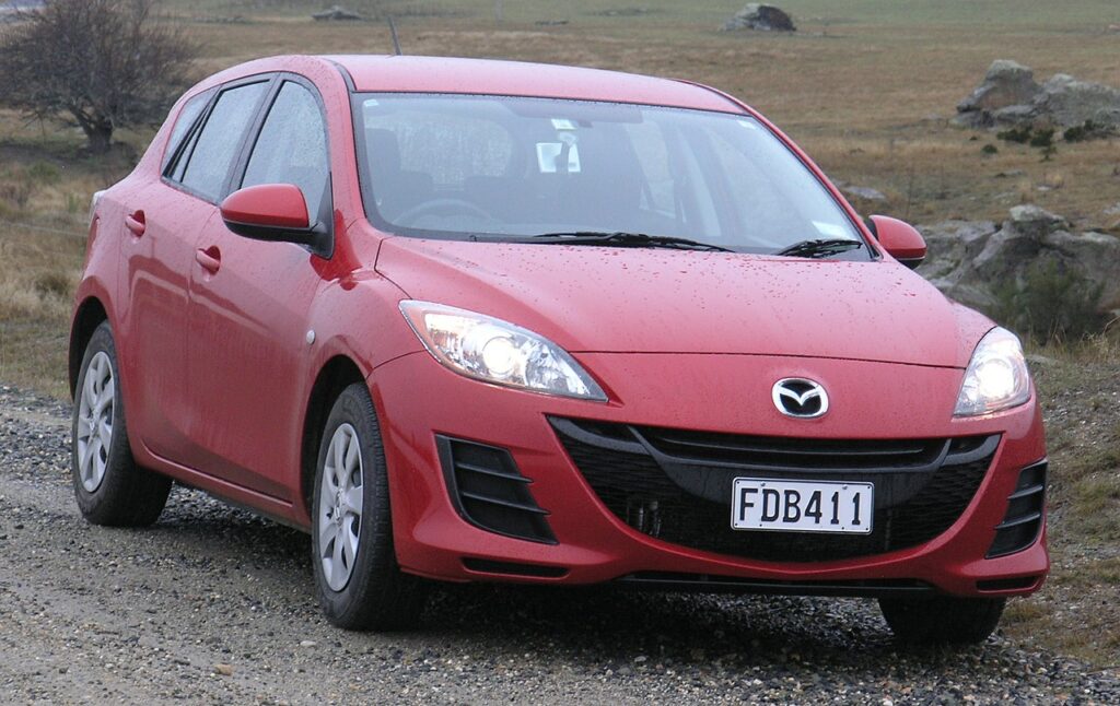 an Image of red 2011 Mazda 3 hatch back as one of the most fuel efficient cars in Australia under $10k