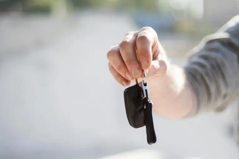 An image of man holding a car key for the article How to Sell Your Car Online